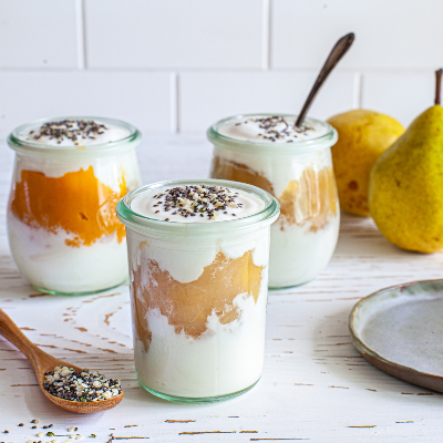 Little jars filled with vanilla yogurt, seasonal compote and superseeds